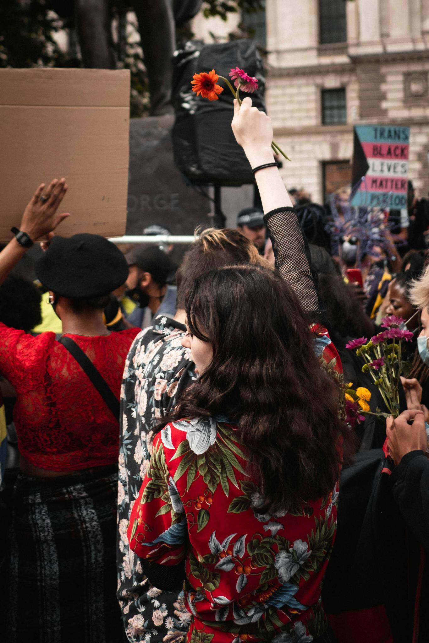 people holding colorful flowers at a human rights rally